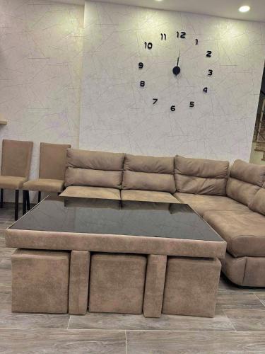 a living room with a couch and a clock on the wall at Wonder Hill group in Bakuriani