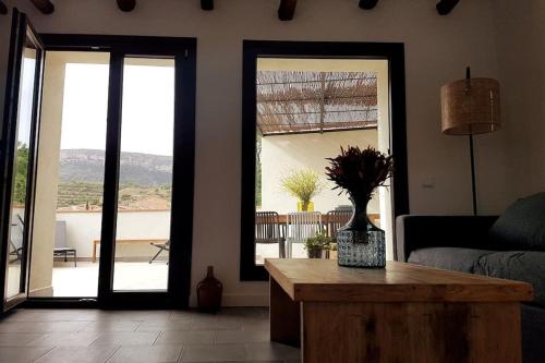 a living room with a table and a view of a patio at El corralet del Lloar, vistes infinites al Priorat in Lloá