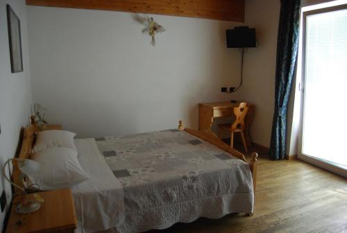 a bedroom with a bed and a table and a window at B&B Nido Delle Aquile in Monclassico