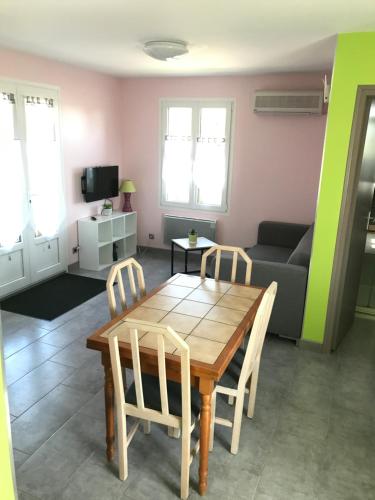 un salon avec une table, des chaises et un canapé dans l'établissement Gîte du moulin, à Saint-Ouen-lès-Parey