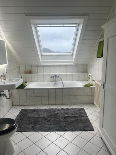 baño con bañera y ventana en Ferienwohnung Mosel en Niederfell