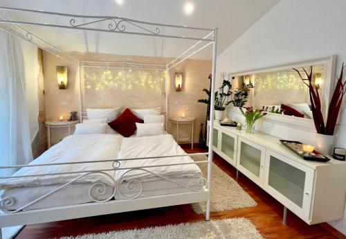 a white bedroom with a white canopy bed and a mirror at 1000qm, Westerwälder Landhaustraum 