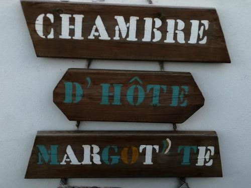 drie houten borden op een muur met de woorden chmite niet merken bij Chambre d'hôte Margot'te in Mimizan