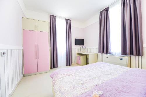 a bedroom with a large bed with purple curtains at Vila Palas in Vrnjačka Banja