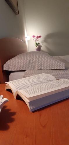 an open book sitting on top of a bed at Agriturismo L'Uliveto in Gargnano