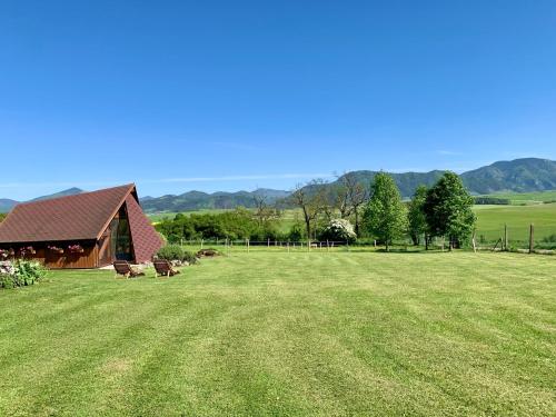 a large grass field with a barn in the background at Apartmán Ranč in Martin