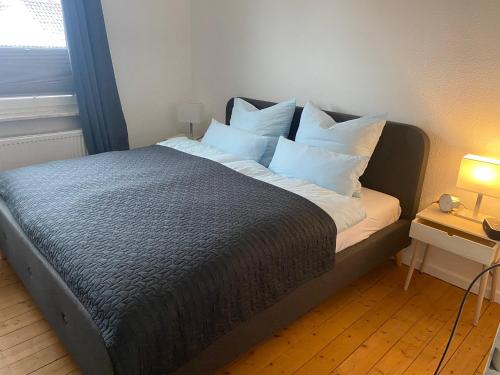 Bett mit weißen Kissen auf einem Zimmer in der Unterkunft Apartment am Palaisgarten, NETFLIX, WLAN, Boxspringbett in Detmold