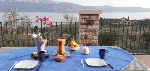 a blue table with plates and utensils on top at Agriturismo L'Uliveto in Gargnano