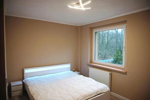 1 dormitorio con cama y ventana en Pokoje gościnne en Stradunia