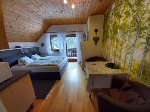 1 dormitorio con 1 cama y 1 mesa en una habitación en Almhaus Blümel, en Turracher Höhe