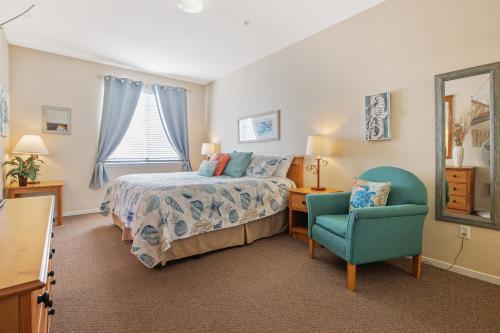 a bedroom with a bed and a blue chair at Pacific Plaza Resort Unit 108 in Oceano