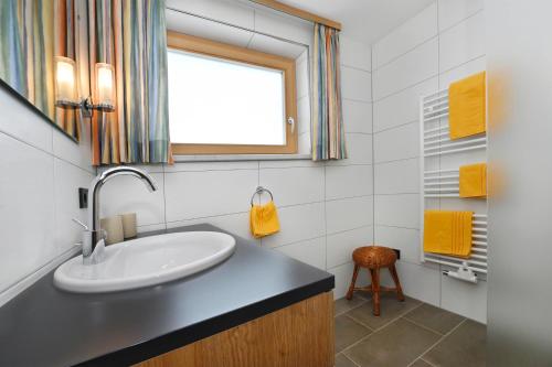 a bathroom with a sink and a window at Haus Valuga in Bürserberg