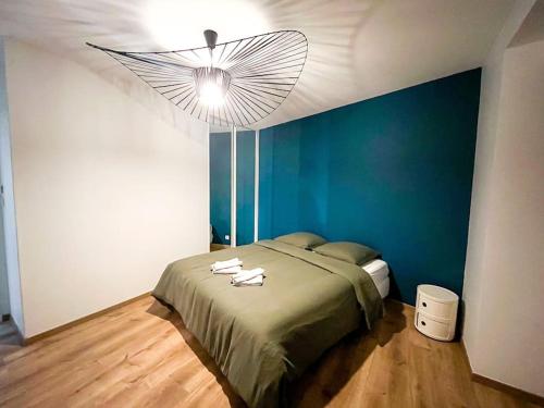 une chambre avec un lit et un mur bleu dans l'établissement Le Rousseau • Haut standing • Duplex • Centre-ville, à Châteauroux
