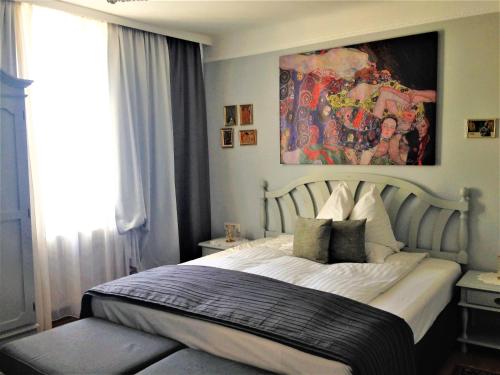 a bedroom with a bed with a painting on the wall at Hotel Schneider-Gössl in Vienna