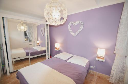 - une chambre violette avec un lit et un miroir dans l'établissement T2 Montpellier centre historique, à Montpellier