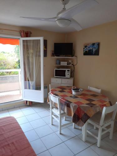 une salle à manger avec une table et une télévision dans l'établissement L’Heure Bleue, à Bormes-les-Mimosas