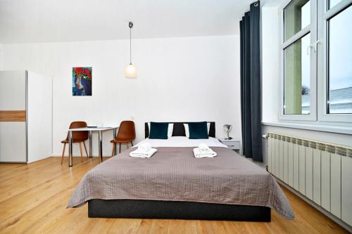 a bedroom with a bed and a table with chairs at Apartamenty MURAL in Bielsko-Biała