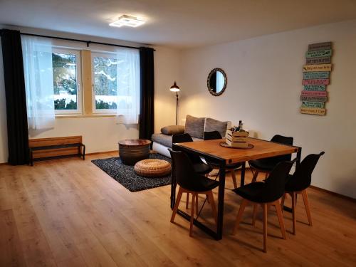 uma sala de estar com uma mesa e cadeiras e um sofá em Ferienwohnung Lieblingszeit em Unterwössen