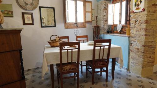 a dining room with a table and chairs and a kitchen at Baglio Sant’Angelo in Licata