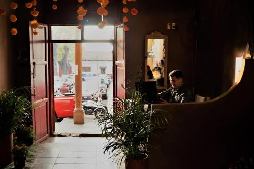 a man sitting at a table with a laptop at Posada El Palomar in Pátzcuaro