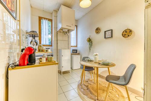 - une cuisine avec une table, une petite table et des chaises dans l'établissement R'Apparts Studio Le Petit Paradis, à Grenoble