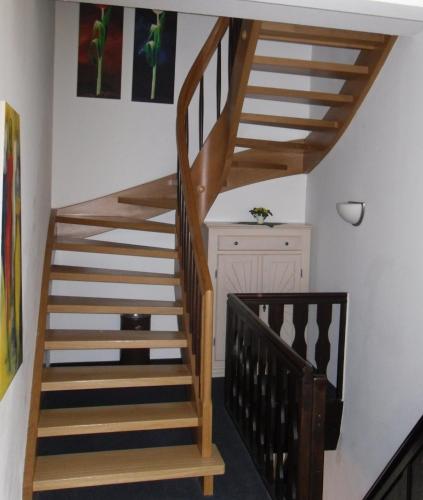 uma escada de madeira num quarto com paredes brancas em Gästehaus Zum Lamm em Lauda-Königshofen