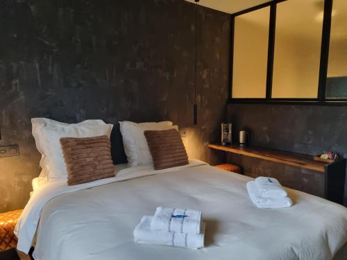 a bedroom with a large white bed with towels on it at Q-time Barvaux, Durbuy-Adults Only in Durbuy