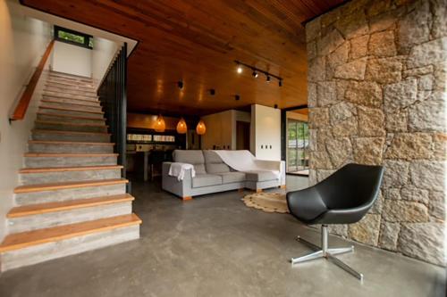 sala de estar con escalera, sofá y silla en Casa moderna prox ao centro na Praia do Rosa SC, en Imbituba