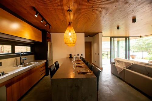 una gran cocina con una larga mesa con sillas en Casa moderna prox ao centro na Praia do Rosa SC, en Imbituba