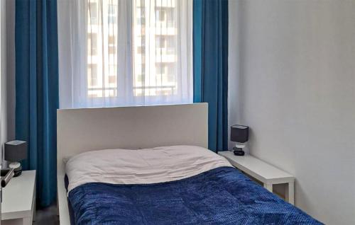 コシャリンにあるAwesome Apartment In Koszalin With Kitchenのベッドルーム1室(ベッド1台、青いカーテン付きの窓付)