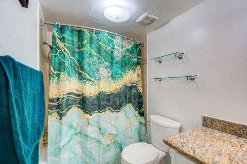 a bathroom with a shower curtain and a toilet at 'Urban Green Living' in Houston
