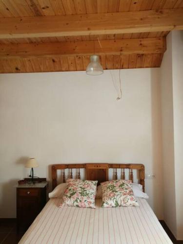 a bed in a bedroom with a wooden ceiling at Casa La Higuera in Chulilla