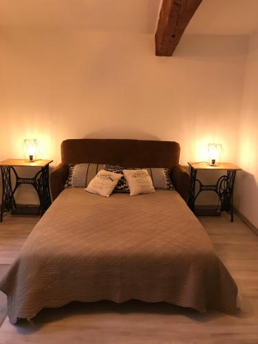 ein Schlafzimmer mit einem Bett mit zwei Nachttischen in der Unterkunft Le grenier de Manée in Villemoustaussou