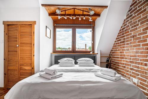 ein großes Bett in einem Zimmer mit Ziegelwand in der Unterkunft Blick Apartments - Riverview Studio Apartment in Zgorzelec