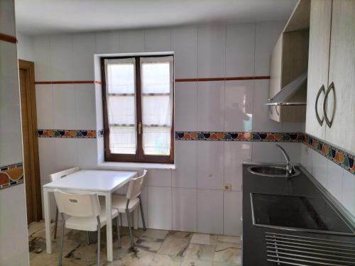 a small kitchen with a table and a window at Don Camino Premium in Villalcázar de Sirga
