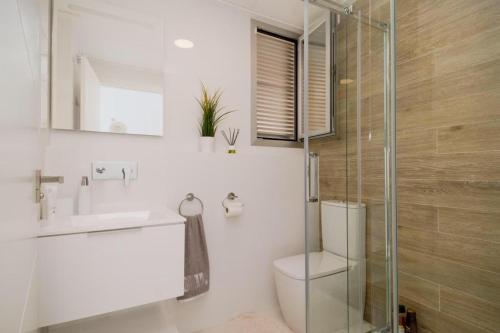 a bathroom with a toilet and a glass shower at Modern villa with pool jacuzzi and sea view in La Horadada