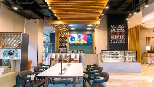a restaurant with a table and chairs and a tv at Holiday Inn Bengaluru Racecourse by IHG in Bangalore
