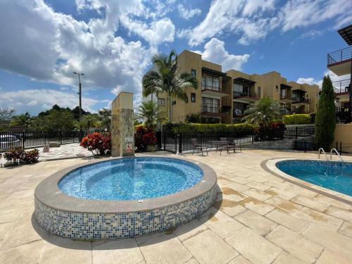 a swimming pool with a fountain in a courtyard at G307Espectacular Apartamento, Condominio Campestre in La Tebaida