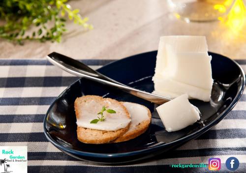a black plate with a piece of bread with cream cheese at R Garden Villa au calme de Baie du tombeau, Appartement familiale de 2 chambres et cuisine in Baie du Tombeau