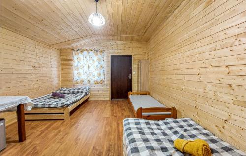 um quarto com 2 camas num chalé de madeira em Cozy Home In Witnica Chojenska With Kitchen 