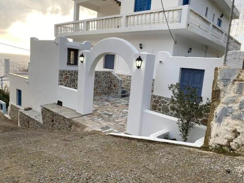 una casa blanca con un arco delante de ella en George's Home Platy Gyalos, en Kalymnos