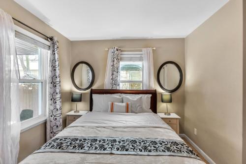 a bedroom with a large bed and two mirrors at Lovely PET FRIENDLY three bedroom in desirable Urbandale Location! home in Wyoming