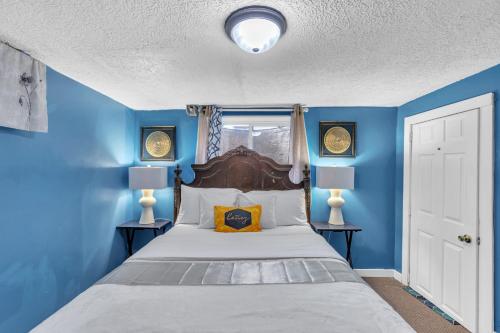 1 dormitorio azul con 1 cama y 2 lámparas en Lovely PET FRIENDLY three bedroom in desirable Urbandale Location! home, en Wyoming