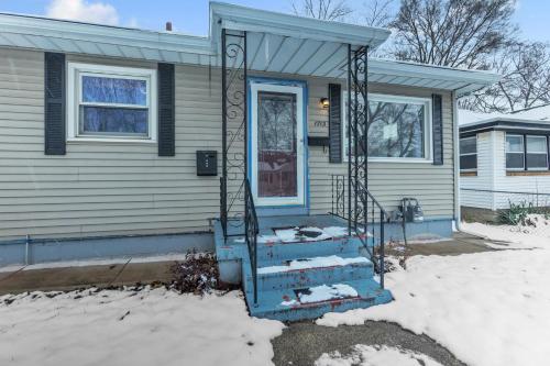 a house with a blue door and stairs in the snow at Lovely PET FRIENDLY three bedroom in desirable Urbandale Location! home in Wyoming