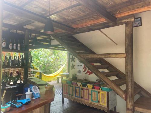 a room with a wooden staircase and books at Pousada Meraki Paraty Mirim in Paraty