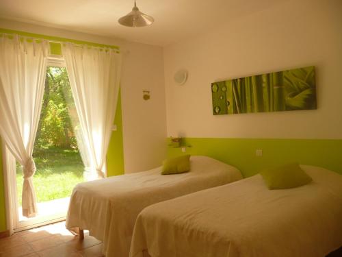 een slaapkamer met 2 bedden en een raam bij MAS DE LA COLOMBIERE in Blauvac