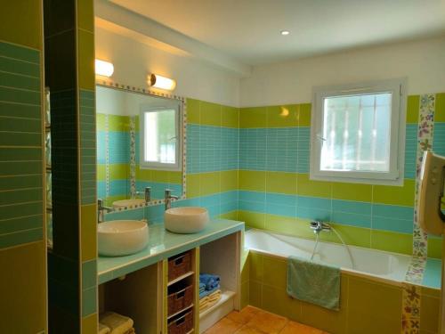 een badkamer met 2 wastafels en een bad bij MAS DE LA COLOMBIERE in Blauvac