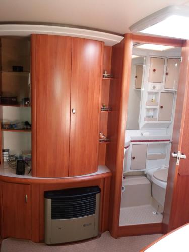 uma pequena casa de banho com WC e um armário de madeira em Forrás camping em Magyarhertelend