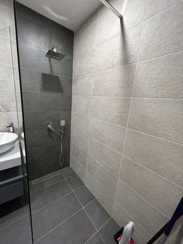 y baño con ducha y lavamanos. en Cozy apartment en Ereván