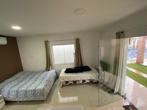 1 dormitorio con 2 camas y ventana en Vila Bangalô, en São José da Coroa Grande